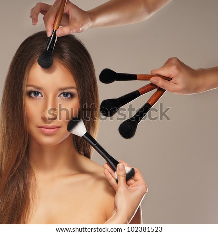 Studio photo of make-up process over grey background
