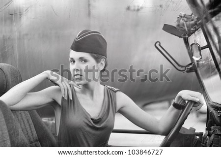Young attractive female soldier driving the car (WARNING! There are noise, dust and scratches on the image)