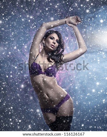 Fashion shoot of young sexy woman in lingerie over the mystical Christmas background
