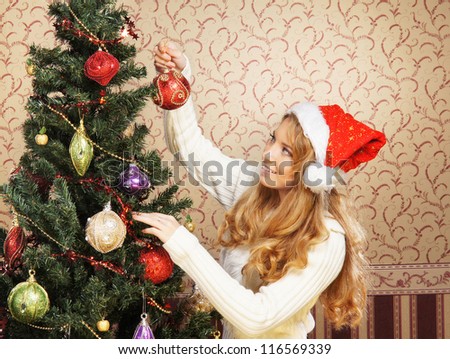 Beautiful teenager girl decorating the Christmas tree