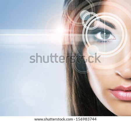 Close-up portrait of young and beautiful woman with the virtual hologram on her eyes (laser medicine and security technology concept)