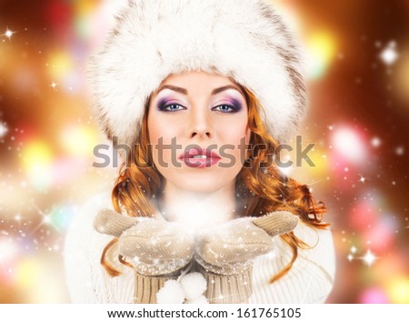 Young and beautiful woman in traditional winter dress over Christmas background