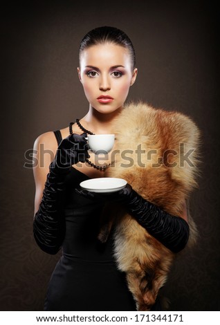 Attractive young lady with the coffee mug over the retro background