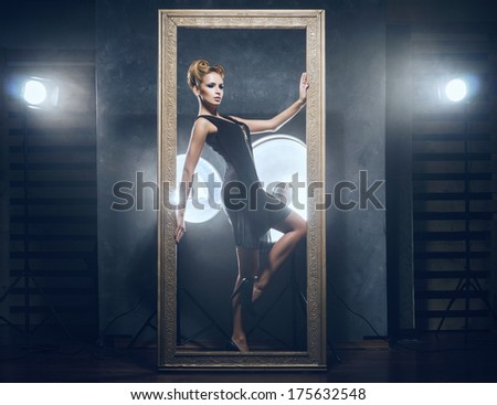 Young and emotional woman in fashion dress over glamour background (studio backstage)