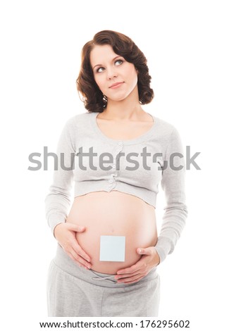 Young, healthy and happy pregnant woman with a sticker on her belly isolated on white