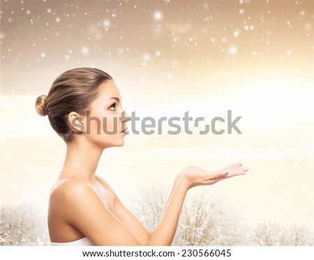 Face of young and healthy girl over winter background with a snowflakes