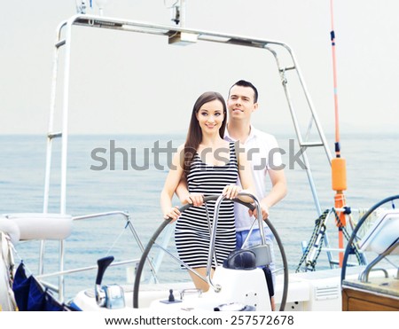 A young and happy Caucasian couple relaxing together on a boat trip.