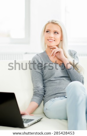 Beautiful blond girl with a notebook pc at home