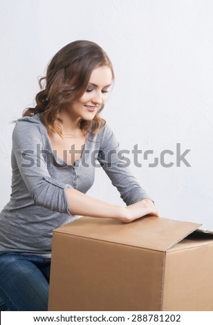 Young and beautiful woman with a big box. Moving and shopping concepts.