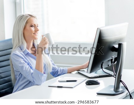 Young, attractive and confident business woman working in office