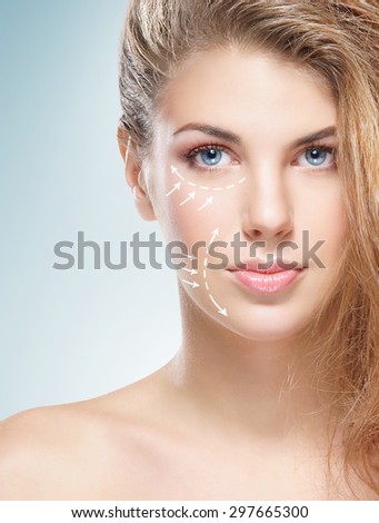 Spa portrait of a young and healthy woman with arrows on her face. Plastic surgery concept.