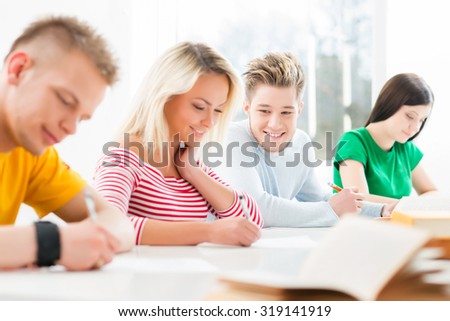 Group of teenage students studying at the lesson in the classroom