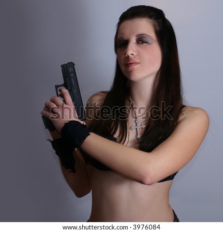 Sexy woman with weapon isolated on grey background