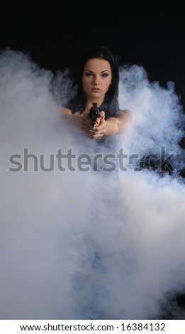Sexy woman with weapon on smoky background