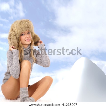 Attractive blond in a winter dress over winter background
