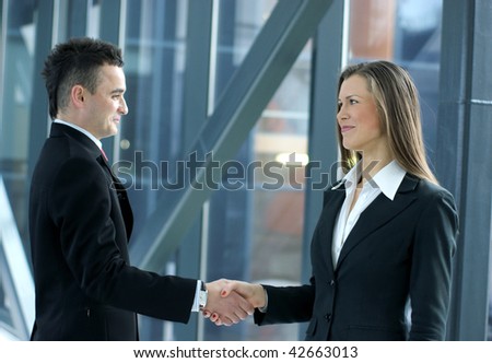 Handshake of young business people over industrial background (Warning! No focus on man!)