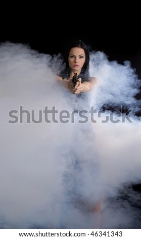 Sexy woman with weapon walks out of smoke