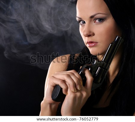 Sexy woman with weapon on a smoky background