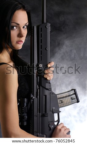 Sexy woman with weapon on a smoky background