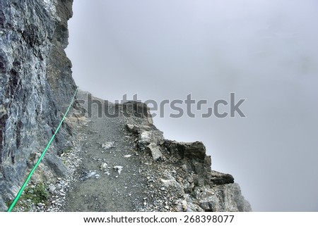 high and steep alpine trail and heavy fog in glacier national park in summer
