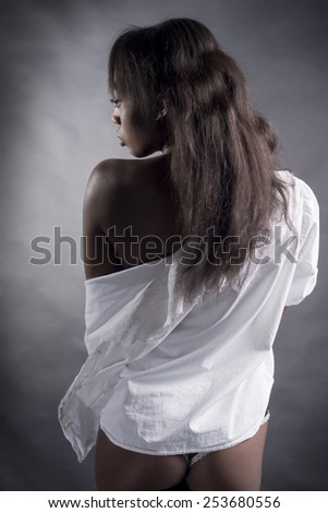 Rear View Of Sexy Black Woman Over Gray Background with white shirt