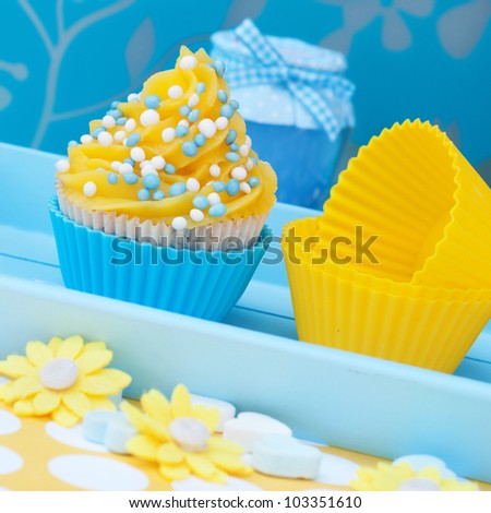 Blue and yellow cupcake setting with flowers