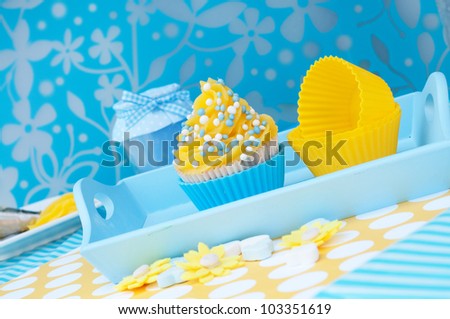 Blue and yellow cupcake setting on a platea