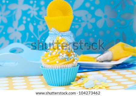 Blue and yellow cupcake setting with empty cups and plateau