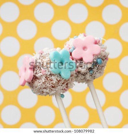 two cakepops with pink and blue sugar paste flowers