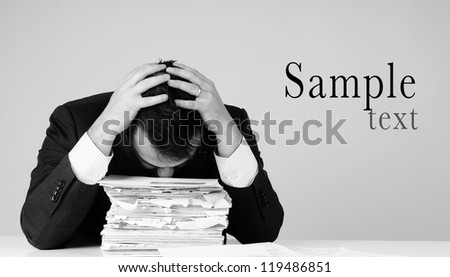 frustrated business man with pile of bills