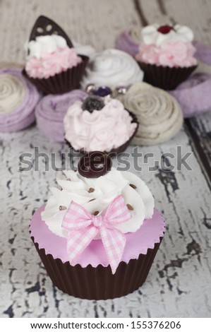 pink baby shower cupcake with a coffee bean and mini cupcakes in the background