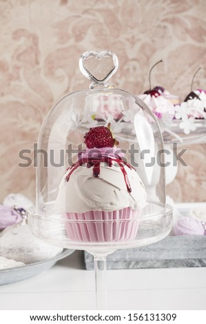 strawberry cupcake on a glass cupcake stand