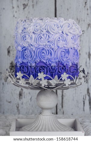 blue rosette cake on cake stand