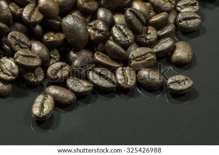 Close-up of coffee beans on black granite.