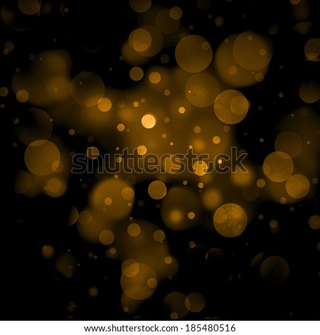 abstract orange gold background, gold bubble lights on black background or snowflakes falling at night. Bokeh Christmas background of circle designs or blurred stars shining, glitter magic background