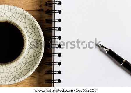 work desk with paper, pen and cup of instant coffee