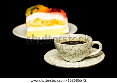 cup of coffee and fruit cake on black background