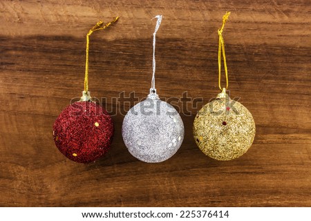 christmas ball red,silver,gold on wood background.