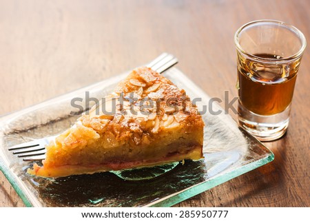 piece of almond cake in dish with honey dip on table.