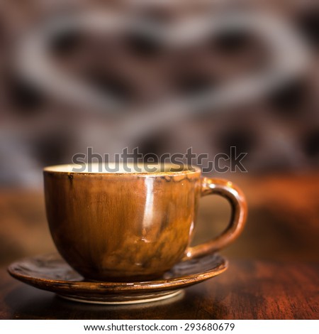 Coffee cup with smoke is heart shape for text on table in cafe.