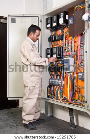 Electrician inspecting wires in electric panel