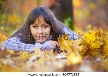 Cute girl in a gold leaf of green forest
