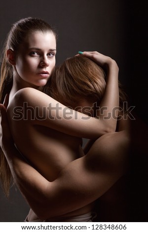 Young couple makes love on dark background