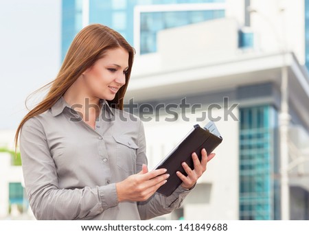 Business woman working on digital tablet outdoor on the background of the modern office
