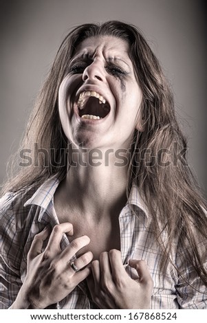 Crying woman on a dark background.  Black and white photo