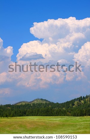 Giant cumulonimbus storm clouds erupt over the landscape of western South Dakota