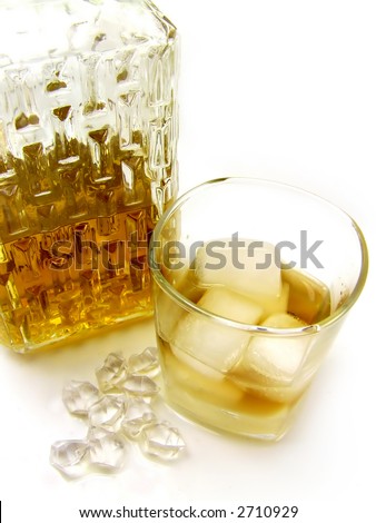 A close-up of a whiskey bottle and whiskey on the rocks.