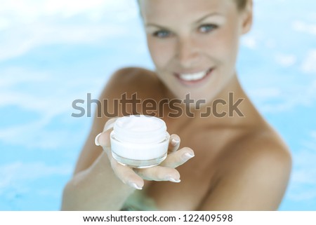 moisturizing cream for body. Woman in swimming pool.