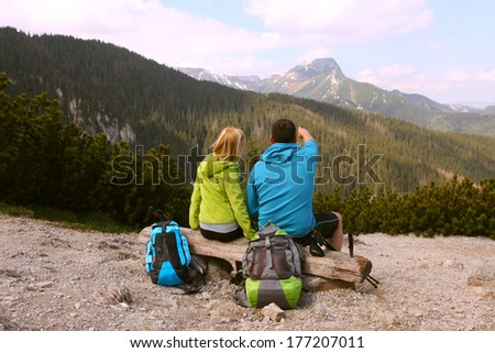 Young people sitting on a bench in the mountains