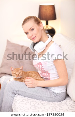 Attractive woman with cat  listens to music